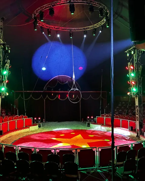 Die leere Manege mit rotem Sternteppich, roten Logenplätzen und Lichtern unter der Zeltkuppel